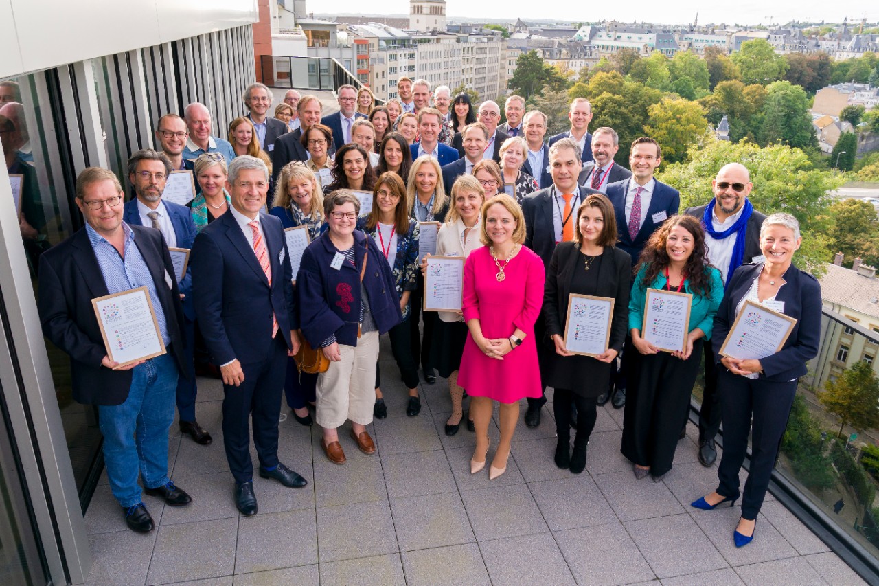 La ministre de la Famille et de l'Intégration, Corinne Cahen, et le président de IMS Luxembourg, Christian Scharff, avec les 26 nouveaux signataires.